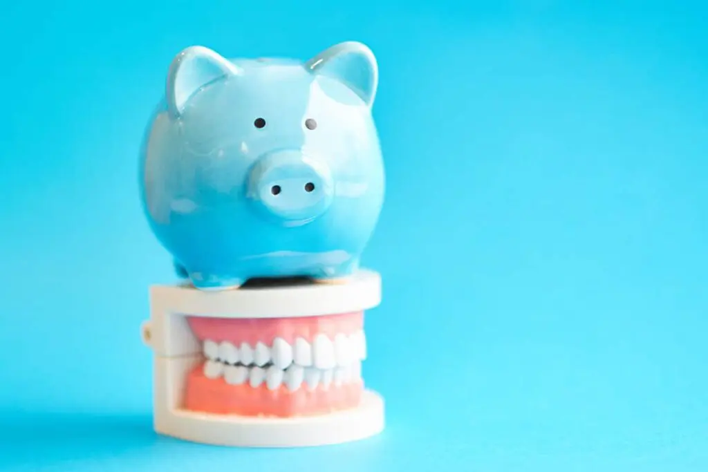 Piggy bank sitting on top of a set of dentures